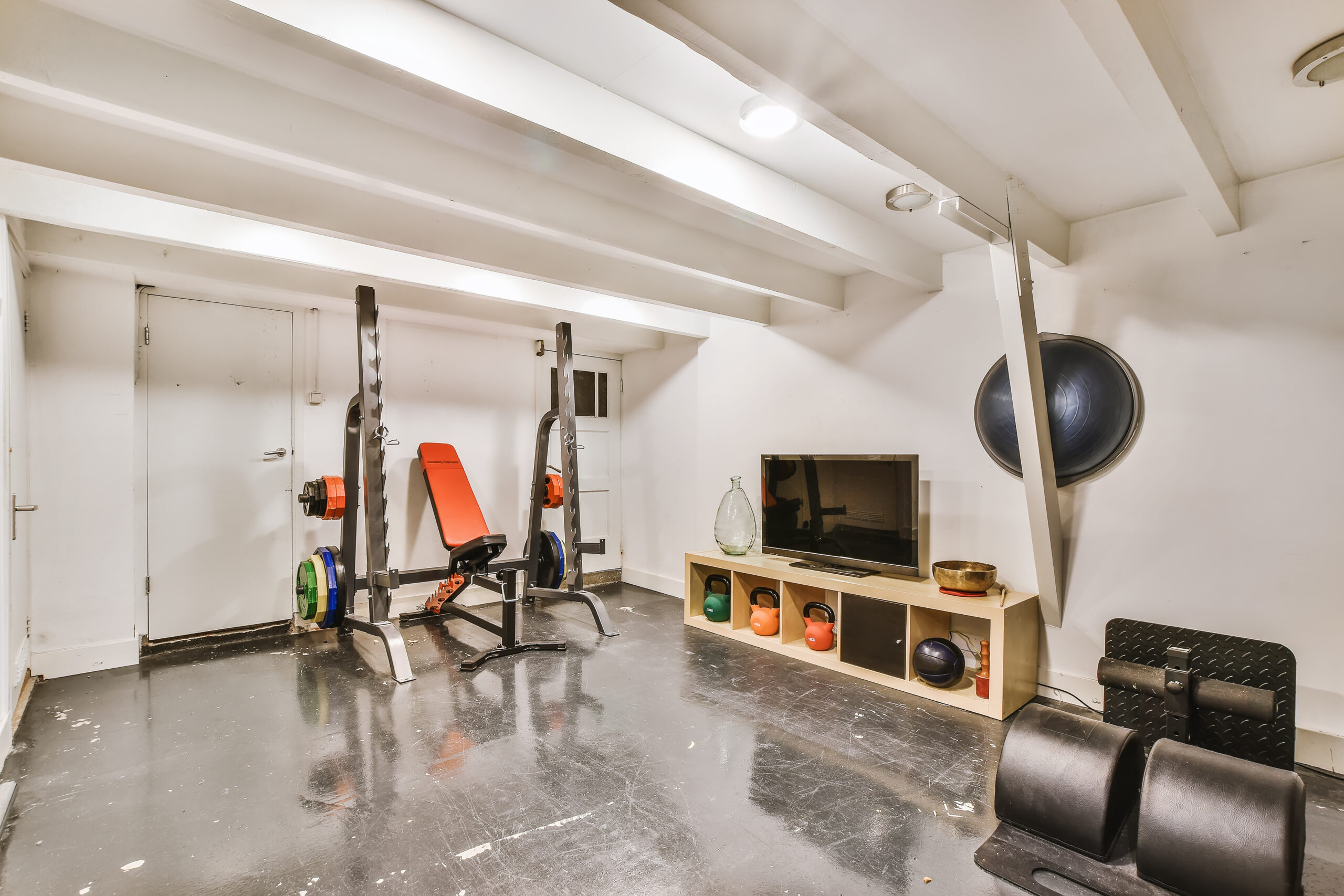 Clean, organized garage interior used as a home gym, kept comfortable by an insulated garage door